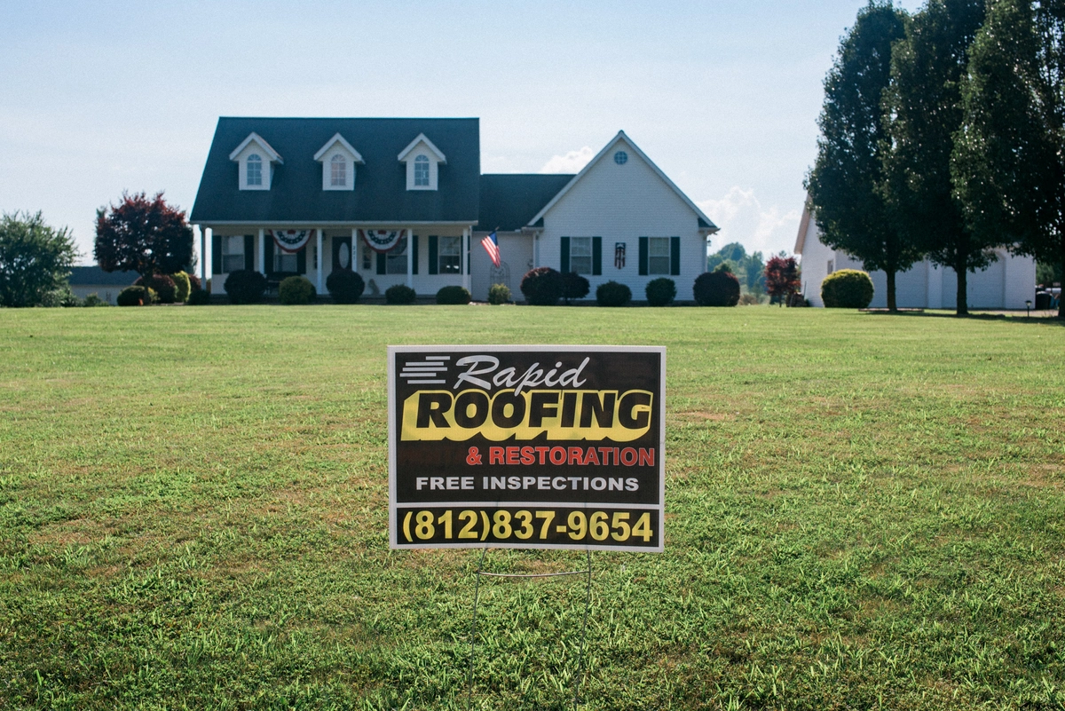 Rapid Roofing sign outside a new roof and siding installation